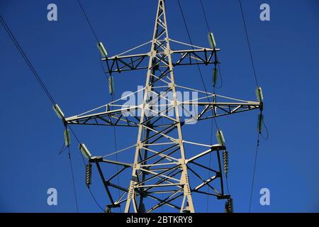 Structure de tour haute tension, fils électriques contre le ciel bleu clair. Banque D'Images