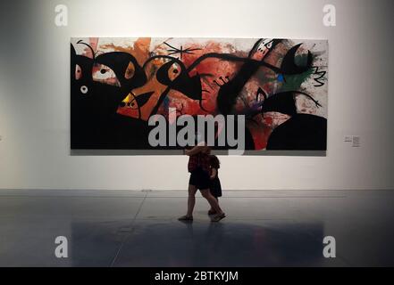 Malaga, Espagne. 26 mai 2020. Une femme portant un masque facial par mesure de précaution, passant devant un tableau pendant l’exposition.« de Miro à Barcelo » une exposition au Centre des musées Pompidou après la réouverture de plusieurs musées importants, garantissant des mesures de sécurité telles que des masques faciaux, des assainisseurs et des balayages de température aux entrées du musée. Crédit : SOPA Images Limited/Alamy Live News Banque D'Images