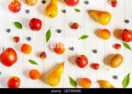 Motif de fruits et de baies sur fond de bois blanc. Banque D'Images