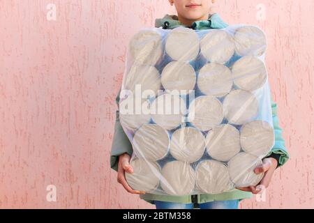 Fille tient un grand paquet de papier toilette. Banque D'Images