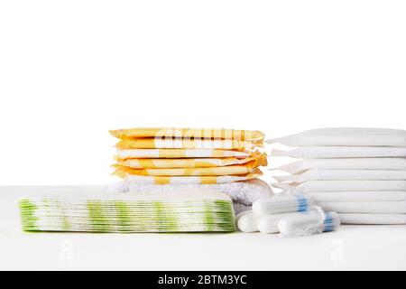 différents tampons et tampons de coton hygiéniques menstruels sur fond blanc. Produits d'hygiène féminine. Espace de copie. Banque D'Images