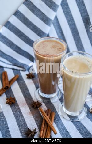 Café glacé avec lait dans de grands verres, tasses de café savoureux à la frappe, Latte machiato, deux tasses de cappuccino avec des bâtons de cannelle et des étoiles anis Banque D'Images