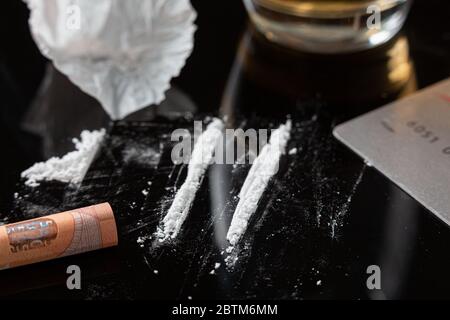 Lignes de cocaïne préparées sur une table et billets roulés prêts à être reniflés Banque D'Images