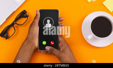 Téléphone portable féminin avec appel entrant de inconnu Banque D'Images