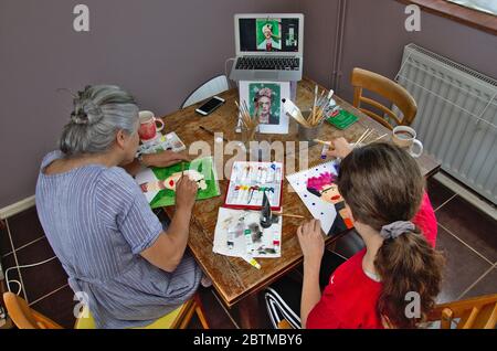 Mère et fille faisant un cours d'art en ligne ensemble apprenant à créer une peinture de style Frida Kahlo. Banque D'Images