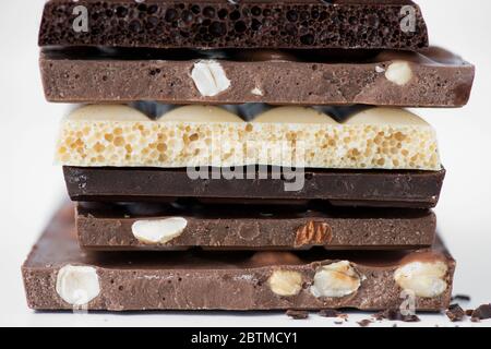 Différents types de chocolats avec noix de cacao en poudre et menthe - foyer sélectif, fond blanc Banque D'Images