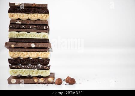 Différents types de chocolats avec noix de cacao en poudre et menthe - foyer sélectif, fond blanc Banque D'Images