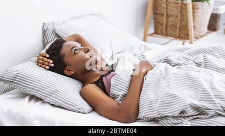 Les pensées ne se laissent pas endormir. La femme est dans le lit et regarde le plafond Banque D'Images