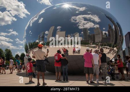 Les gens se présentent eux-mêmes leurs réflexions, avec les gratte-ciel de Chicago comme arrière-plan, à la sculpture Anish Kapoor Cloud Gate (The Bean), Millenium Park Banque D'Images