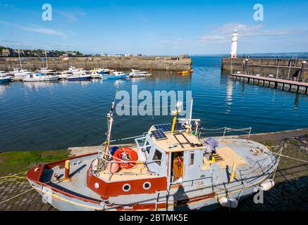 Newhaven, Édimbourg, Écosse, Royaume-Uni, 27 mai 2020. Météo au Royaume-Uni : les bateaux de pêche amarrés dans l'eau calme du port créent des réflexions avec un seul bateau sur le port Banque D'Images