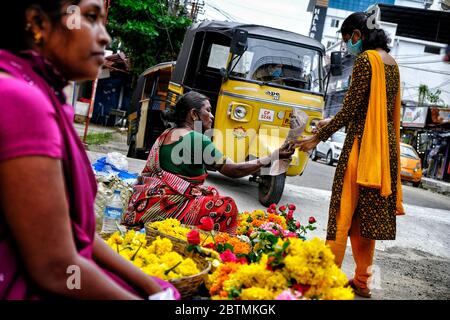 Kochi, Inde. 26 mai 2020. Une femme portant un masque facial comme mesure préventive achète des fleurs dans la rue pendant le Lockdown. Au début de la quatrième phase d'un confinement national à Kerala, plusieurs relaxations et de nouvelles directives pour l'État doivent être suivies pendant cette période de confinement prolongé. Crédit : SOPA Images Limited/Alamy Live News Banque D'Images