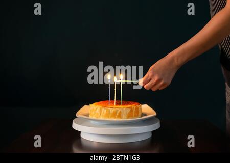 Bougies allumées sur gâteau d'anniversaire isolé sur fond noir. Banque D'Images