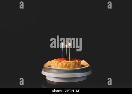 Gâteau d'anniversaire, bougies allumées isolées sur fond noir. Banque D'Images