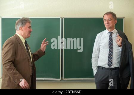 27 mai 2020, Saxe-Anhalt, Stendal: Roland Herms (l.), directeur de l'école secondaire 'Wladimir Komarow', se dresse devant un tableau de surveillance avec Marco Tullner (CDU), ministre de l'éducation de Saxe-Anhalt, et est heureux. Le ministre a remis les décisions de financement fédéral pour les salles de classe numériques à plusieurs directeurs d'école. Près de huit mois après le début du programme de financement des salles de classe numériques, les premières écoles peuvent maintenant acheter de la technologie. La plupart des écoles l'utilisent pour étendre leurs lignes Internet et leurs réseaux WLAN et installent des appareils tels que des tablettes, des beamers et des appareils interactifs Banque D'Images