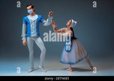 Cendrillon moderne n'essaie pas la pantoufles, mais masque facial protecteur. Jeunes danseurs de ballet gracieux pendant le spectacle en studio. Art, mouvement, action, flexibilité, inspiration concept. Banque D'Images