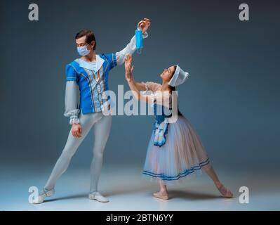 Cendrillon moderne n'essaie pas la pantoufles, mais masque facial protecteur. Jeunes danseurs de ballet gracieux pendant le spectacle en studio. Art, mouvement, action, flexibilité, inspiration concept. Banque D'Images