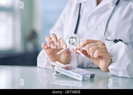 Doctor's hands holding a broken cigarette, concept de vie sain Banque D'Images