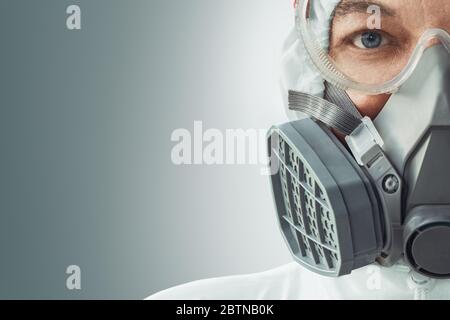 Portrait d'un médecin masculin dans un respirateur, des lunettes et une combinaison de protection biologique contre l'infection à coronavirus. Protection COVID-19. Banque D'Images