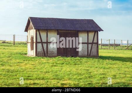 Ancienne grange sur un champ vert herbacé dans le camp allemand de concentration et d'extermination Majdanek. Lublin, Pologne Banque D'Images