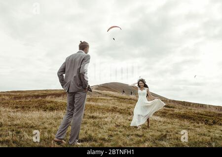 bonne mariée magnifique courant à la mariée et de s'amuser, cérémonie de luxe à la montagne avec vue incroyable, espace pour le texte, couple de mariage de boho Banque D'Images
