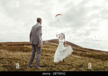 bonne mariée magnifique courant à la mariée et de s'amuser, cérémonie de luxe à la montagne avec vue incroyable, espace pour le texte, couple de mariage de boho Banque D'Images