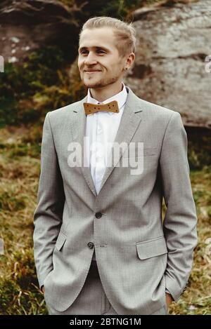 marié élégant posé sur des rochers de fond à la montagne, mariage de luxe de boho Banque D'Images