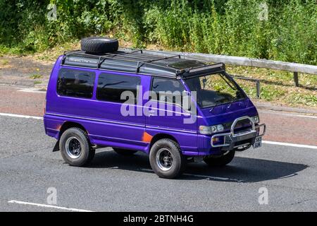 1994 90s années quatre-vingt-dix violet Mitsubishi Delica Window van kombi avec porte-bagages de toit et pneu de secours; véhicules de circulation de véhicule, véhicules, routes, caravane, voyage, camping, transport, kombi, vacances, camping-cars tourisme, motorhome van, window van combi, microbus sur l'autoroute M6 Banque D'Images