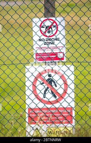 Gros plan du panneau d'avertissement public du ministère de la Défense « No Drone zone » derrière la barrière de sécurité, clôture en maille de chaînette, RAF Fairford, Royaume-Uni. Aucun signe d'accès. Banque D'Images