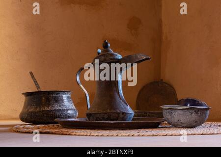 Pot à café de style omanais appelé dallah et bols devant le mur d'argile brun, Nizwa Banque D'Images