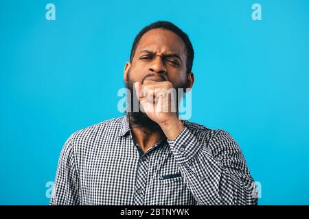 Homme noir fatigué bâilling couvrant la bouche ouverte avec la main Banque D'Images
