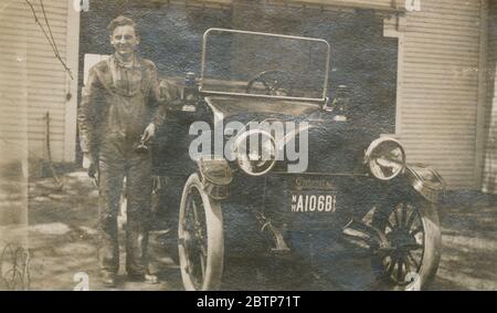 Photographie antique d'avril 1913, New Hampshire homme travaillant sur son automobile Detroiter. Le Detroiter a été réalisé par la Briggs-Detroiter Company de Detroit, Michigan. SOURCE : PHOTO ORIGINALE Banque D'Images