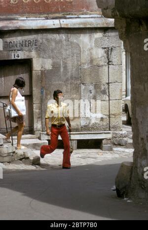 Personnes marchant à travers la partie médiévale d'Auxerre, France photographiée en 1973 Banque D'Images