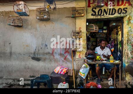 Un vendeur d'oiseaux colombien répare les vieux orateurs dans son atelier au marché des oiseaux à Cartagena, Colombie. Banque D'Images