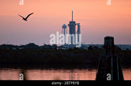 Cape Canaveral, États-Unis d'Amérique. 27 mai 2020. La fusée SpaceX Falcon 9 transportant le vaisseau spatial Crew Dragon au complexe de lancement 39A pendant un lever de soleil orageux le jour de lancement au Kennedy Space Center le 27 mai 2020 à Cape Canaveral, Floride. La mission de démonstration-2 SpaceX de la NASA est prévue pour le lancement le 27 mai comme premier lancement commercial transportant des astronautes à la Station spatiale internationale. Crédit: Joel Kowsky/NASA/Alay Live News Banque D'Images