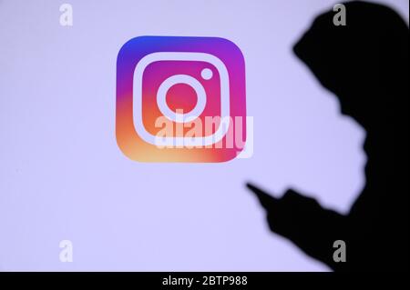 NEW YORK, ÉTATS-UNIS, 25. MAI 2020: Instagram photo et vidéo-partage de réseau social chat jeune garçon sur téléphone mobile. Logo de la société à l'écran dans bac Banque D'Images