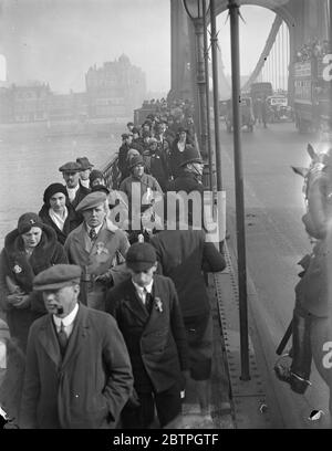 Rassemblement de foules . Des foules se rassemblent pour la course de bateaux Oxford contre Cambridge . La foule passant par le pont Hammersmith pour prendre position pour voir la course de bateau . 19 mars 1932 Banque D'Images