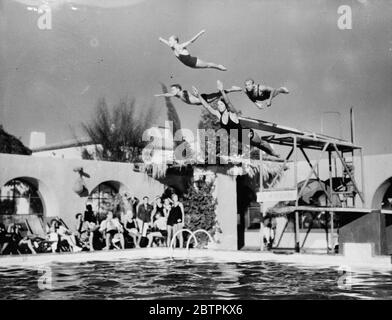 Grâce dans l'air . Une plongée de masse gracieuse par une quartette de célèbres nageurs , qui doivent participer aux épreuves des Jeux Olympiques , dans une exposition à Palm Springs , Californie , Etats-Unis . De gauche à droite - Marjorie Jestring , Jim Moller , Johnny Riley et Ruth Jump . 25 novembre 1935 Banque D'Images