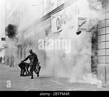 raid aérien sur Vienne . L'exercice de lutte contre les RAID aériens organisé à Vienne par le Gouvernement autrichien a été le plus réaliste à la mémoire de la Viennèse . ' poison gaz ' est monté dans les nuages , ' bombes ' a explosé et des pompiers et des travailleurs de premiers soins ont toilé au milieu des épaves de bâtiments et de véhicules . Expositions de photos , police à gaz masqué transportant une victime à la sécurité 16 septembre 1935 Banque D'Images