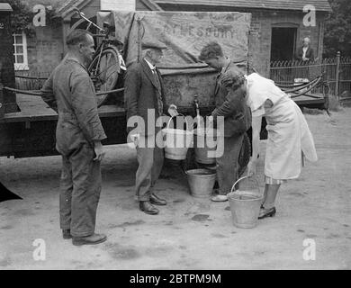 La sécheresse augmente dans Buckinghamshire . Les villages reçoivent des approvisionnements en eau de lorrys . Photos , villageois de Kingswood , Buckinghamshire , recevant leurs approvisionnements en eau d'un camion-citerne . 9 août 1935 Banque D'Images