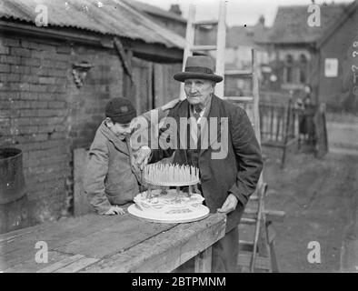 106 ans . Jimmy Miles , célèbre centenaire de Southampton , célèbre son anniversaire de 106 . Photos , Jimmy Miles coupant son gâteau d'anniversaire de 106 regardé par son petit-fils plus jeune. 17 mars 1937 Banque D'Images