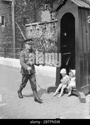 Changer de lieu ! Deux petits Londoniens se réfugient à l'ombre de la boîte de sentry à la tour de Londres a été le malheureux sentry est laissé à la merci du soleil!. 29 mai 1937 Banque D'Images