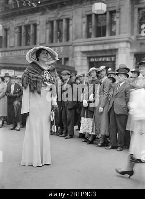 Défilé de mode Ascot à Waterloo. Photos : une femme de course haute dans un grand chapeau et un four cape excite l'admiration d'une galerie alors qu'elle quitte la gare de Waterloo pour le deuxième jour de la réunion d'Ascot. 16 juin 1937 Banque D'Images