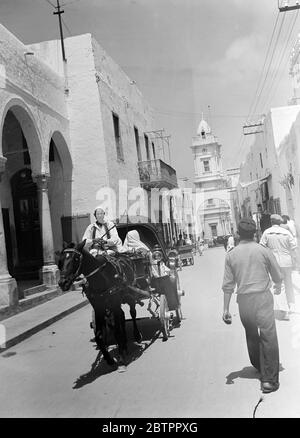 Marché libyen. Curieux de visiter, une femme arabe est conduite à Tripoli dans un taxi arabe. La femme arabe garde toujours son visage couvert et voit avec un œil à travers un petit espace dans sa couverture comme une tenue. Banque D'Images