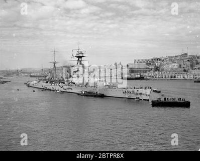 Le plus grand navire de guerre au monde à Malte. Le HMS Hood, le plus grand navire de guerre au monde à l'ancre dans le port de la Valette, capitale de Malte, où les navires de la Marine britannique se sont massés avant de partir sur les exercices combinés des flottes Home et Méditerranée, transférés dans l'Atlantique Sud, en raison du danger dans les eaux espagnoles. La ville de la Valette, qui renferme de nombreuses reliques de l'occupation des anciens chevaliers de Malte, se balade derrière le « Hood ». Cette photo a été prise de 'HMS courageux' alors que le porte-avions entrait dans le port. 5 mars 1937 Banque D'Images