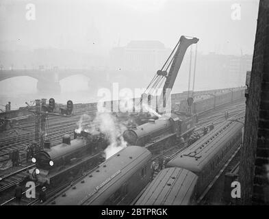 Le rail de Cannon Street est en train de se briser. Plusieurs autocars ont été gravement endommagés, causant une grave désorganisation de la circulation lorsqu'un train de passagers vide et un moteur léger ont heurté à l'extérieur de Cannon Street, gare du sud. À la suite de l'accident, la station a été temporairement fermée à la circulation. Plusieurs lignes ont été bloquées et de nombreux trains ont été détournés. Photos, scène de l'accident devant la station Cannon Street. 3 janvier 1938 Banque D'Images