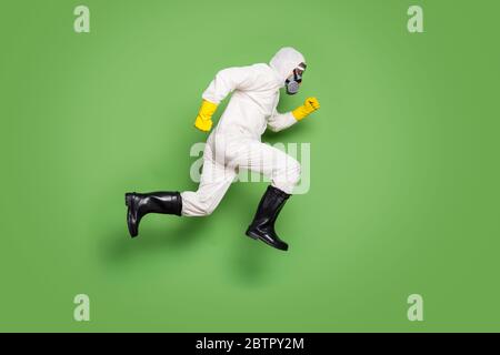 Profil plein côté photo homme saut courir pressé covid19 patient arrêter épidémie porter blanc noismat costume jaune latex gants lunettes masque respiratoire Banque D'Images