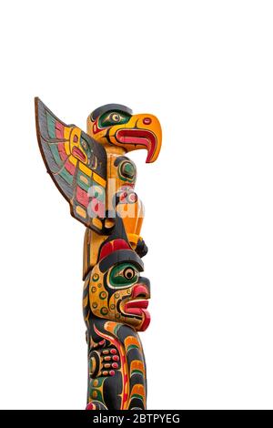 Mât de totem canadien sculpté en bois coloré sur fond blanc Banque D'Images