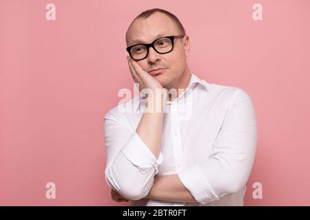 Jeune homme beau avec des lunettes pensant ou rêvant à l'avenir. Banque D'Images