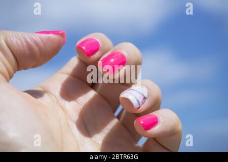 Main de femme montrant sa manucure semi-permanente. Couleur rose Banque D'Images