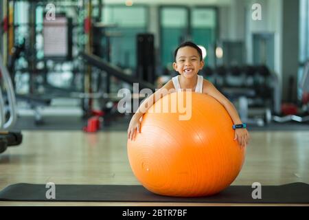 Enfant asiatique avec ballon de gymnastique Banque D'Images